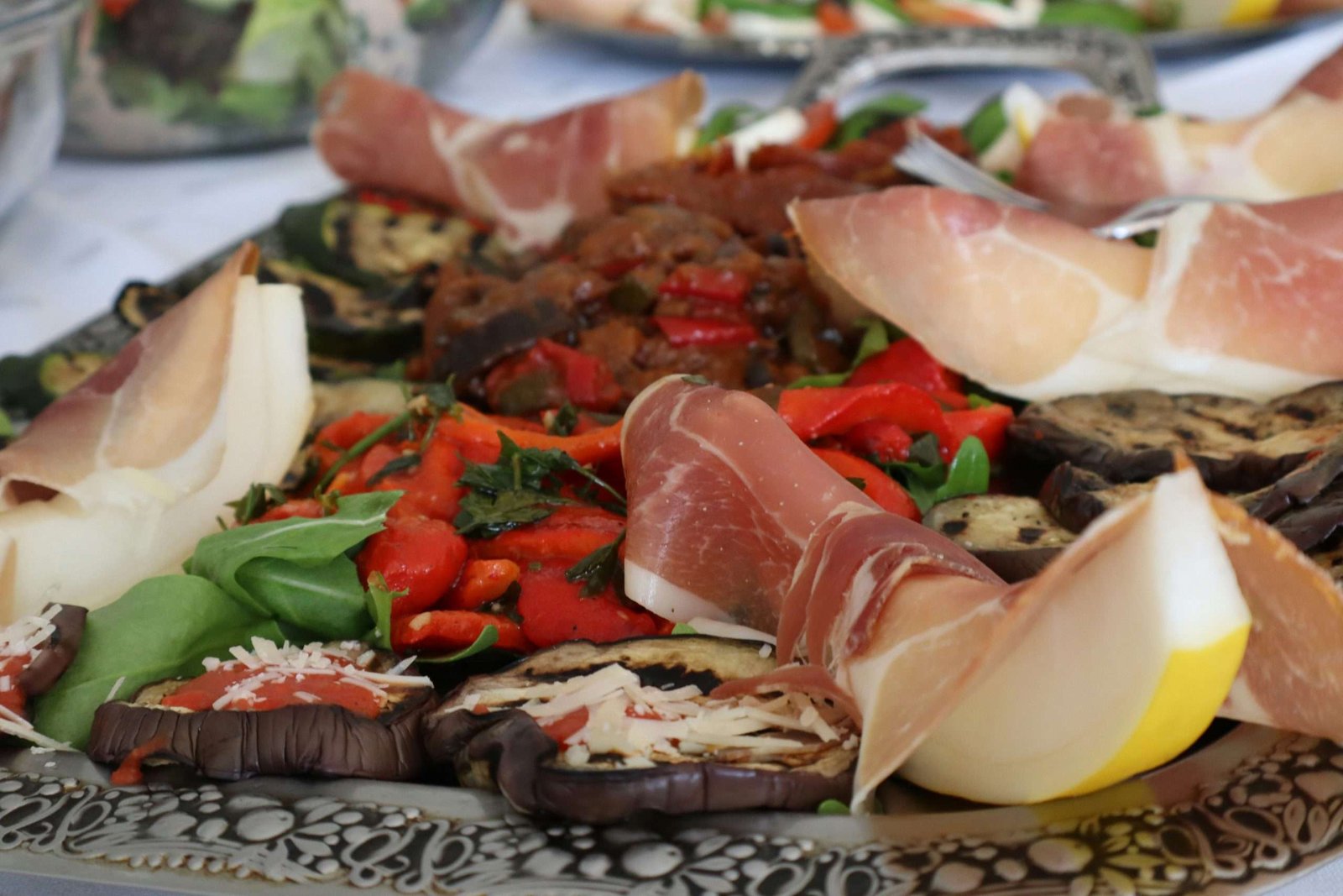 Mediterraneo culinario: cucina mediterranea prosciutto e melone con pomodori, cibo tipo mediterraneo