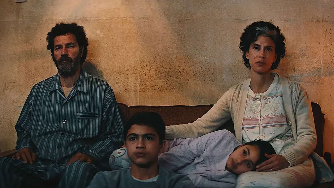 scena dal film tutto quello che resta di te, protagonisti del film seduti sul divano mentre guardano la televisione